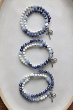 This beautiful gemstone rosary bracelet features Blue Angelite beads as the paters with a combination of Sodalite beads and white howlight beads beads as the aves. Each of our stretch and wrap rosary bracelets is a full rosary. Each bracelet also includes a “bookmark”crucifix medal. This medal is moveable and can help you keep track of where you are at in your rosary as you pray throughout your day. Each bracelet is strung on durable elastic making it easy to stretch and wrap around your wrist without fear of snapping it. The medal accent pieces will oxidize, creating an antiqued, rustic look. Lotions and perfume usage does speed up the oxidization look. Please note: The Small Rosary Bracelets do not include the first three aves, and the Large Rosary bracelets have spacers on each side of Small Rosary, Rosary Ideas, Diy Rosary, Catholic Rosary Bracelet, Custom Jewelry Necklaces, Mens Rosary, Rosary Making, Catholic Bracelet, Mini Rosaries