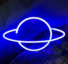 a blue neon sign that is on top of a table in front of a laptop