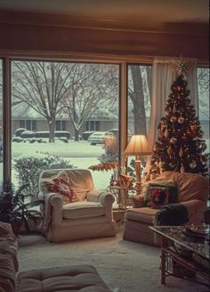 a living room filled with furniture and a christmas tree in front of a large window