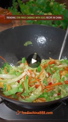 a wok filled with vegetables on top of a stove