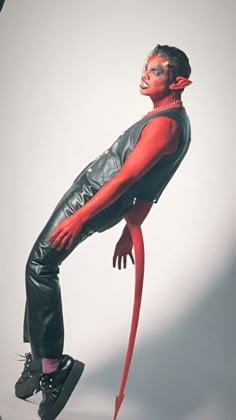 a man dressed in black and red poses with his legs spread out to the side