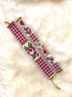 a pink and white bracelet with roses on it sitting on a furnishing area