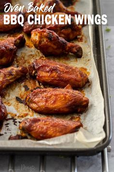 oven baked bbq chicken wings on a baking sheet with text overlay that reads oven baked bbq chicken wings