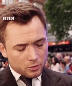 a man in a suit and tie looking down