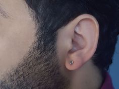 a close up of a man's ear with a small diamond in the middle