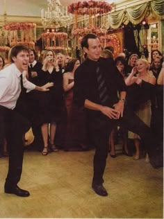 two men are dancing on the dance floor in front of a group of other people