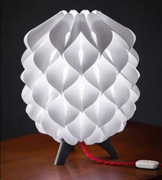 a white lamp sitting on top of a wooden table