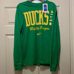 Brand New And Never Worn Nike University Of Oregon Ducks Football Long Sleeve T-Shirt In A Size Medium. Nike Collegiate Long Sleeve T-shirt, Game Day Graphic Tee With Long Sleeves, Nike Long Sleeve Cotton T-shirt, Nike Green Graphic Print T-shirt, Graphic Tee Long Sleeve Top For Game Day, Long Sleeve Screen Print T-shirt For Game Day, Nike Long Sleeve T-shirt For Spring, Fan Apparel Long Sleeve Top With Logo Print, Long Sleeve Logo Print Fan Apparel Top