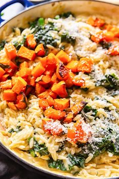 pasta with spinach, carrots and parmesan cheese in a skillet