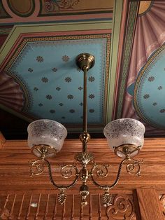 a chandelier hanging from the ceiling in a room with blue and pink walls