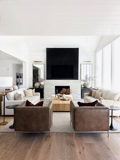 a living room filled with furniture and a flat screen tv mounted on the wall over a fireplace