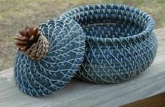 two blue baskets sitting on top of a wooden table next to a window sill