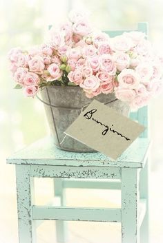 there is a bucket full of pink roses on top of a chair with a sign that reads, decor maker fb