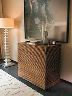 a wooden cabinet sitting next to a lamp on top of a white carpeted floor