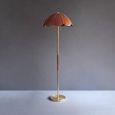 a lamp that is on top of a table next to a gray wall and floor