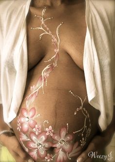 a pregnant woman with flowers painted on her belly