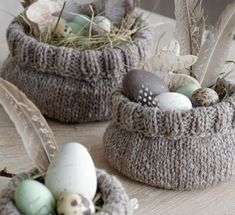 three knitted baskets filled with eggs and feathers