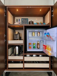 an open refrigerator filled with drinks and condiments next to a wall mounted microwave