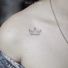 a woman's chest with a small crown tattoo on the left side of her breast