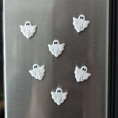 six white ghost buttons on a stainless steel refrigerator