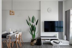 a living room filled with furniture and a flat screen tv mounted on a wall next to a dining table