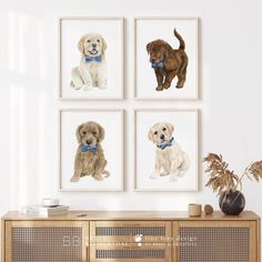 four dogs are hanging on the wall next to a wooden cabinet and vase with plants in it