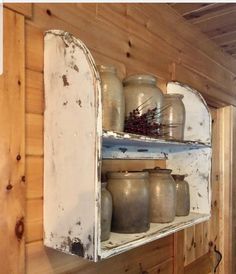 an old wooden shelf with jars and vases on it's shelves in a cabin