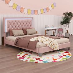 a bedroom with a pink bed and lots of decorations on the wall, along with an area rug