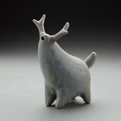 a ceramic figurine of a dog with antlers on it's head