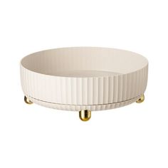 a white bowl with gold handles on it