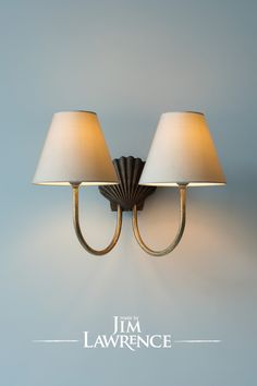 two lamps mounted on the wall next to each other in a room with blue walls