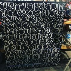 an art piece is being worked on in a studio with black and white lettering, including letters