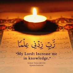 a lit candle sitting on top of a table next to a piece of paper with arabic writing