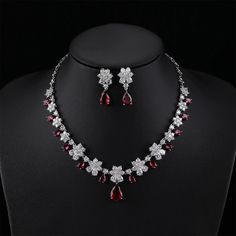 a necklace and earring set with red stones on a mannequin neckline