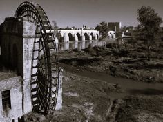 a black and white photo of a water wheel