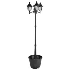 a black lamp post with two lights on top and a potted plant in the middle