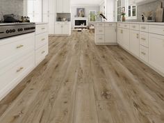 a large kitchen with white cabinets and wood flooring