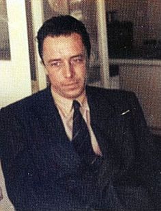 a man in a suit and tie sitting at a table