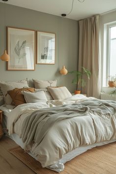 a large bed sitting in a bedroom next to a window with two pictures on the wall