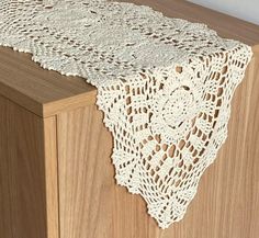 a white doily on top of a wooden cabinet