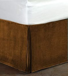 a bed with a brown skirt on top of it