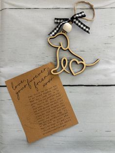 a wooden dog ornament with a note attached to it on a white table