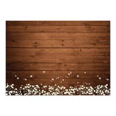 a wooden background with white flowers on the bottom and lights in the middle, as well as