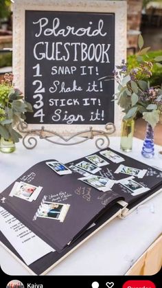 a sign that is on top of a table with flowers in vases next to it