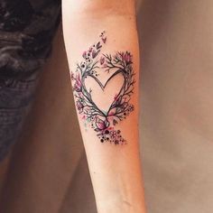 a woman's arm with a heart tattoo on it