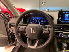 the interior of a car with dashboard, steering wheel and touchscreens on display