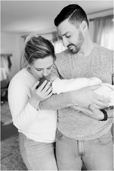 a man and woman holding a baby in their arms