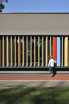 a man walking past a multicolored building