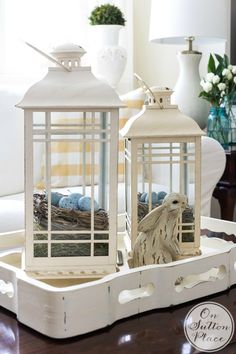 two white bird cages sitting on top of a tray