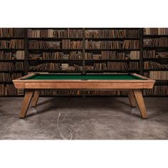 a pool table in front of a bookshelf